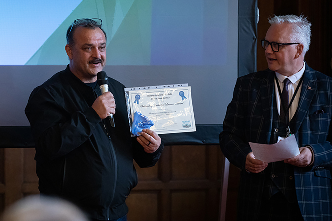 Learner accepting an award from a member of staff