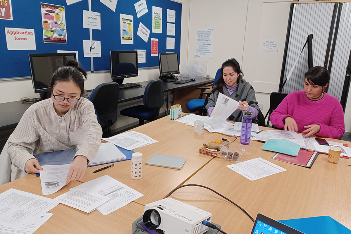 Group of learners with papers in a classroom