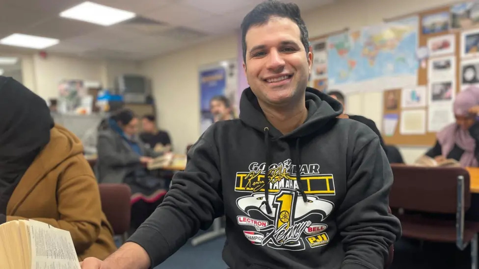 Man sitting at a desk smiling