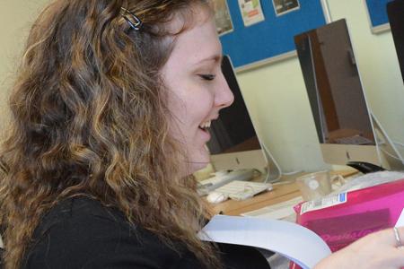 Learner at a computer receiving support from a member of staff